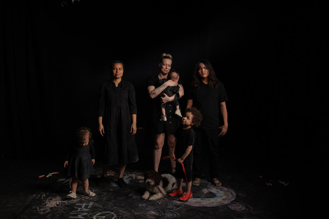 Eine Familie mit Kindern und Hund vor schwarzem Hintergrund